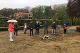 thumbnail: Een aantal nabestaanden van overledenen wiens graf werd ontgraven, legden symbolisch een krans neer op de ontruimde zone.