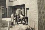 thumbnail: Karel Van Peer en zijn familie staan enkele tientallen jaren geleden bij het naaiatelier van de kledingzaak in Poederlee. 