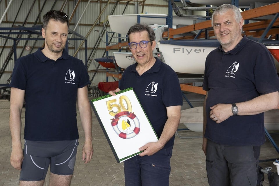 Bestuursleden Gert, Bart en Jan vieren de vijftigste verjaardag van de watersportclub. 