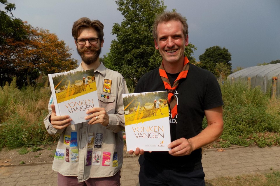 Raf Van Rooy () en Karel Taeymans tonen de pas gedrukte exemplaren van Vonken Vangen, het jubileumboek naar aanleiding van 75 jaar scouts Lille. 