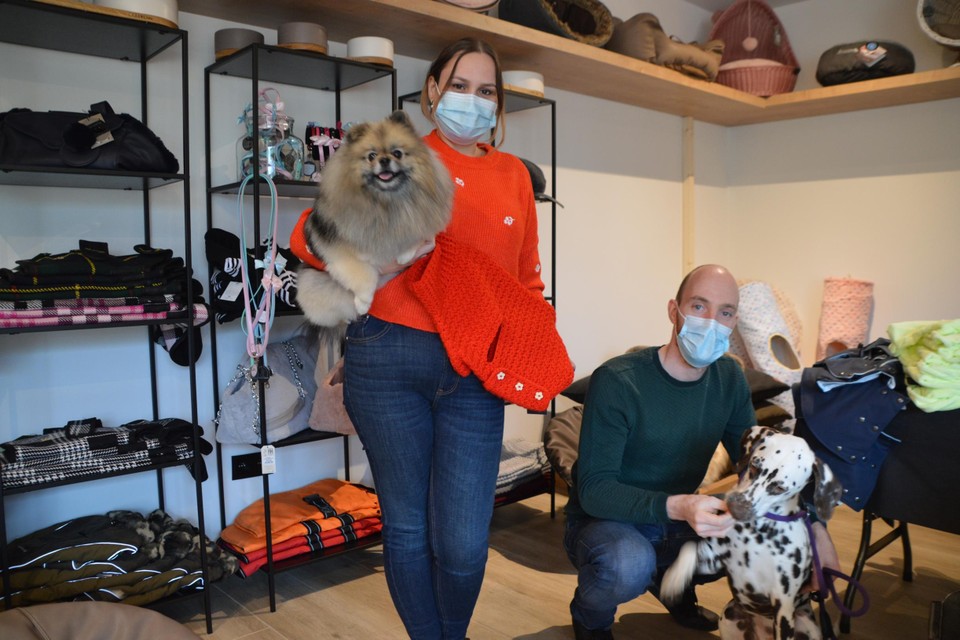Melissa Broos met pluizige Vigo onder haar arm en een handgemaakte hondenjas in haar andere hand. Rechts Mathias met dalmatiër Pip.  