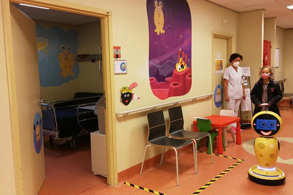 Robot Cheese neemt de tienjarige Féline op sleeptouw door de gangen van de kinderafdeling, die al omgedoopt is tot Planeet Goudgeel met zijn koddige ruimtewezens. 