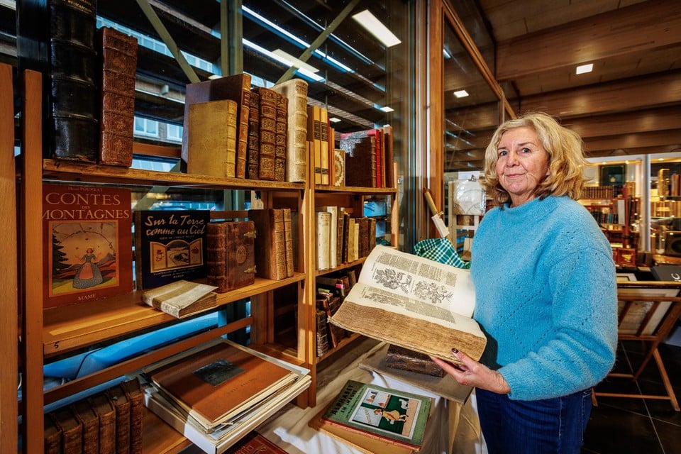 Isabelle Garcia van Antiquariaat Garcia in Mechelen, doorbladert een kruidenboek van Dodoens. 