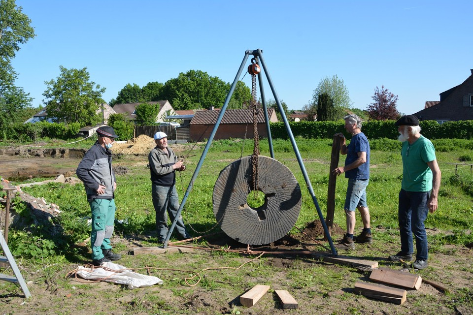 Leden van heemkring De Brakken met de molensteen uit 1823 die in de Rundvoortstraat bij het uitgraven van een werf werd opgegraven.