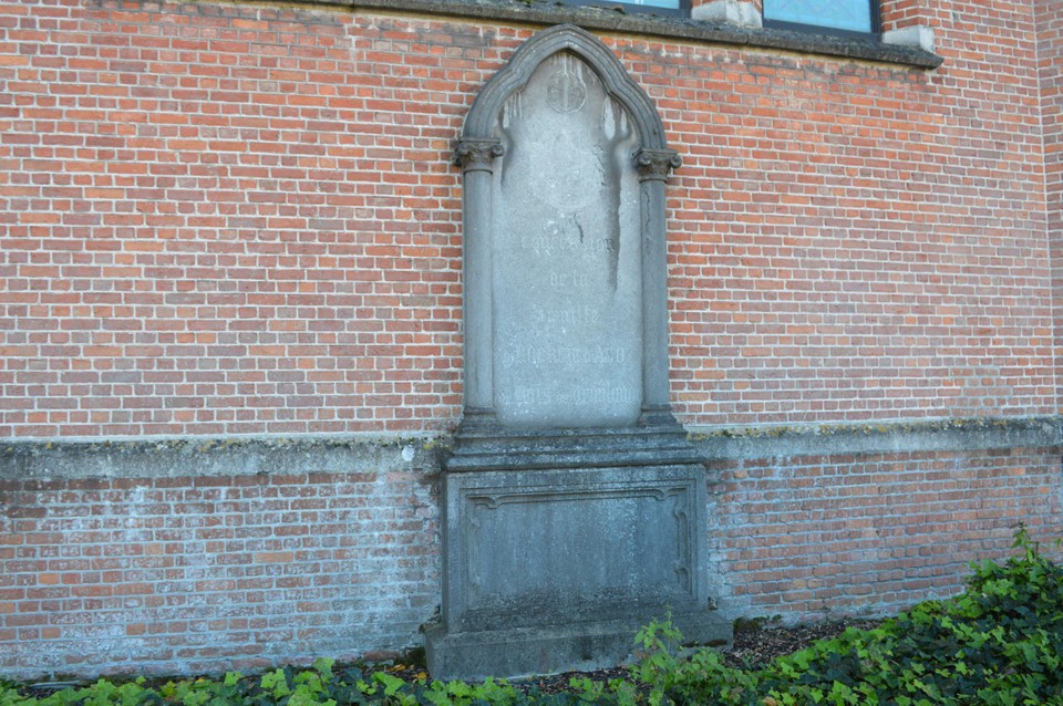De steen van de familie d’Udekem d’Acoz-du Bois de Vroylande aan de kerkmuur in Halle, aan de kant waar de auto’s parkeren. 