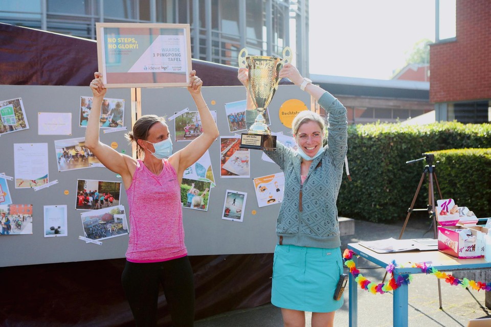 Medewerkers Liesbeth Buytaert en Sofie Dauwen, psychomotore therapeuten, tonen hoe blij ze zijn met de trofee.