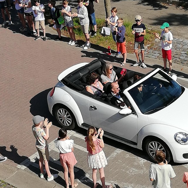 De drie trouwe leerkrachten werden in een open auto naar basisschool Triangel in Vlimmeren gereden.