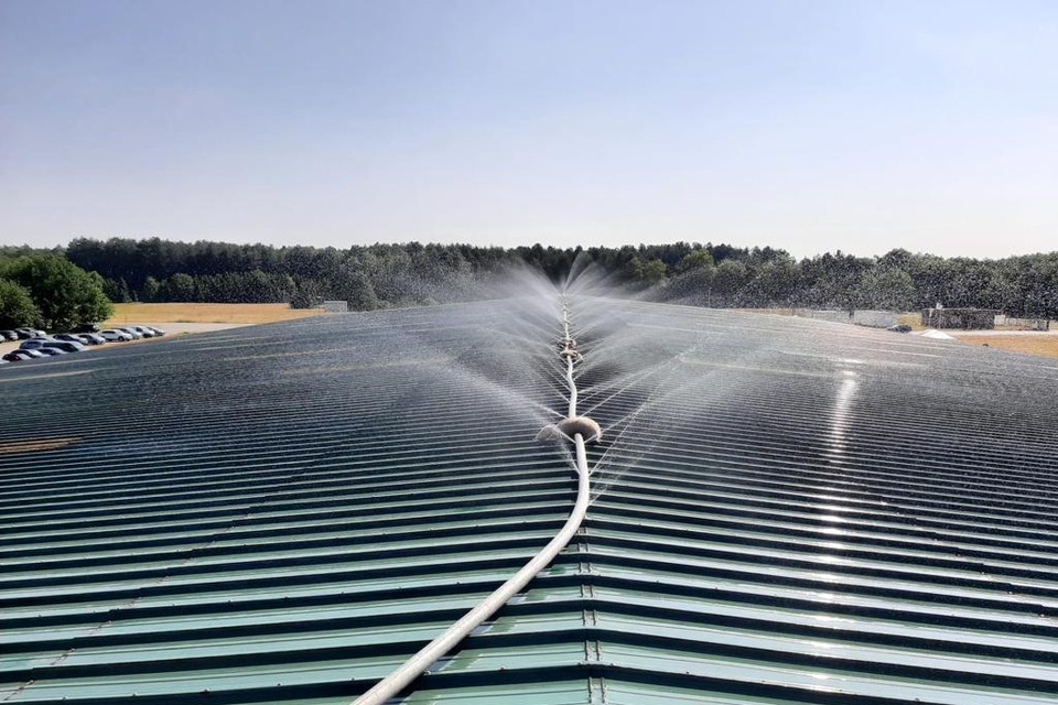De installatie sproeit koud water op het dak van de loods.
