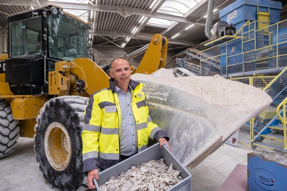General manager Maarten Hendriks met op de achtergrond de gepatenteerde machine die gipsafval verpulvert. Het papier van de verwerkte gipsplaten wordt ook in de bouw hergebruikt.