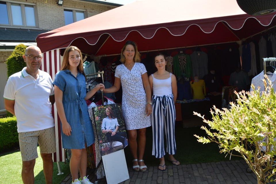 Stefan Van Goethem en Carine Theus met dochters Zoë (17) en Axelle (14) voor hun ‘tuinmarktkraam’, allemaal uitgedost in kleding die ze op de markt verkopen. 