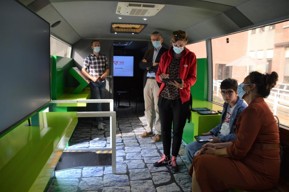 Esila doet de verkeersquiz met een tablet binnen in de Mobibus.