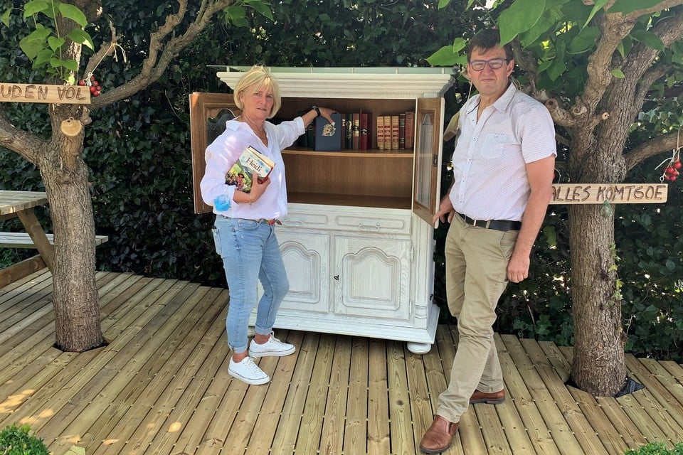 Schepenen Lili Stevens en Luc Van Houtven vullen de boekenruilkast.
