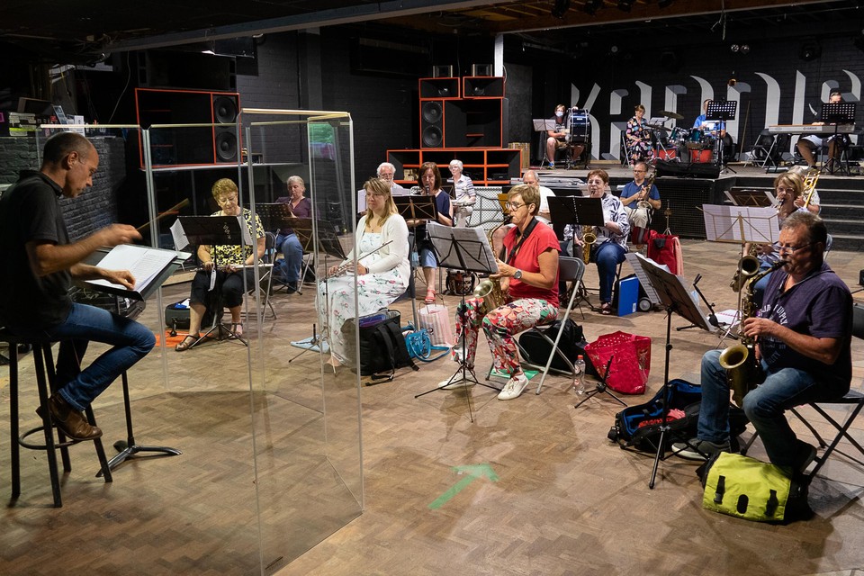 Dirigent Niko Deman achter zijn pupiter - achter een plexiwand- in jeughuis Kaddish en met zijn muzikanten van Sinte-Cecilia. Na zeven maanden stilte mogen ze eindelijk weer samen repeteren, mits een aantal voorzorgsmaatregelen.