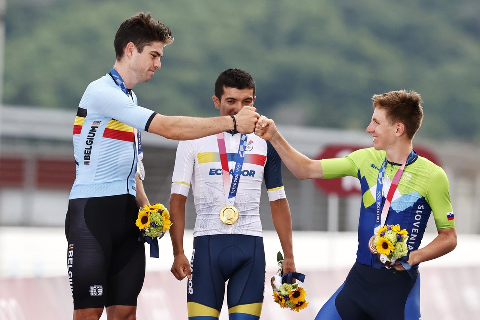 Vuistje met bronzen Tadej Pogacar. Olympisch kampioen Richard Carapaz kijkt met de glimlach toe.