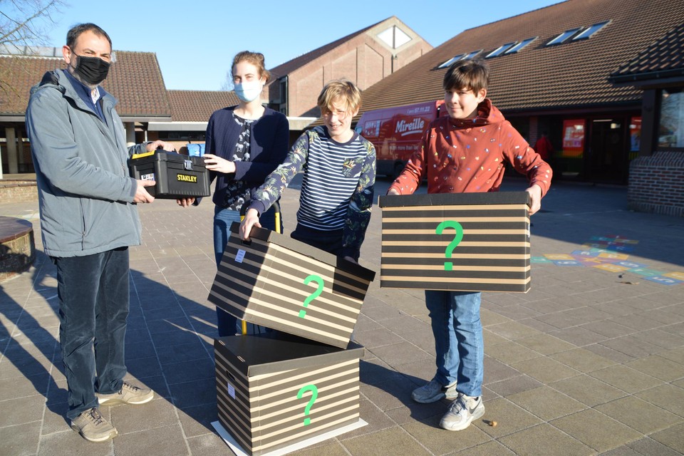 Staf Teunen overhandigt een bak met gereedschap aan juf Ine van de school Beuk & Noot. Hiermee kunnen Vic (11) en Bram (11) samen met de rest van de zesdeklassers de verrassingspakketten die in de technoboxen zitten in elkaar knutselen.