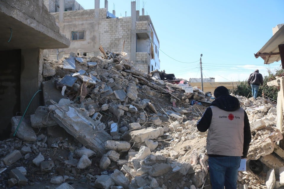 Een hulpverlener van Caritas Syrië overschouwt de schade.