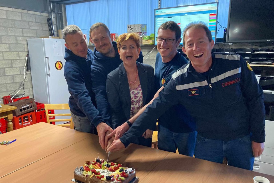 Burgemeester Marleen Peeters van Lille snijdt samen met de kersvers gediplomeerde brandweervrijwilligers Joris Baeten, Tim Bilterest, Peter Belmans en Stef Hooybergs een taart aan.