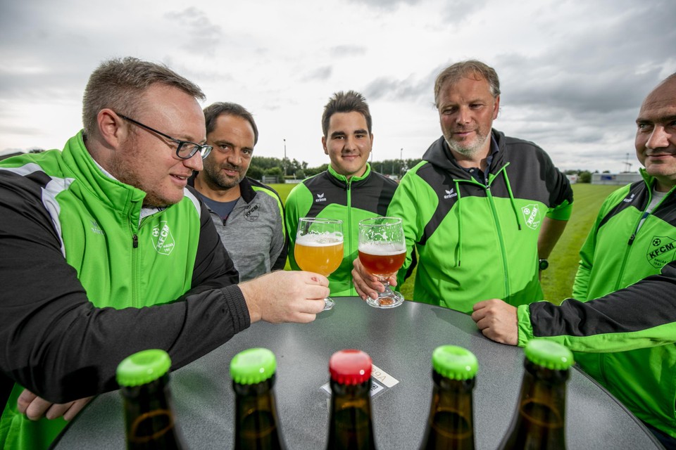 De bestuursleden heffen het glas op en met hun nieuwe biertjes. 