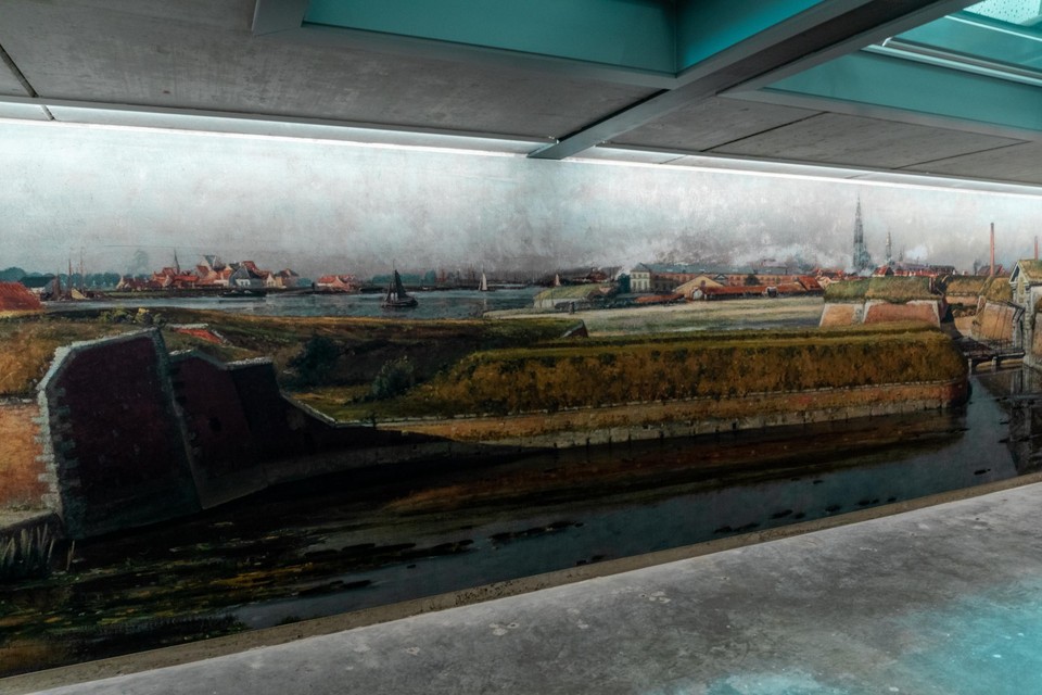 Naast de restanten van de vestingmuur hangt een afbeelding met een uitzicht op de citadel, met het Vlaams Hoofd op de achtergrond.