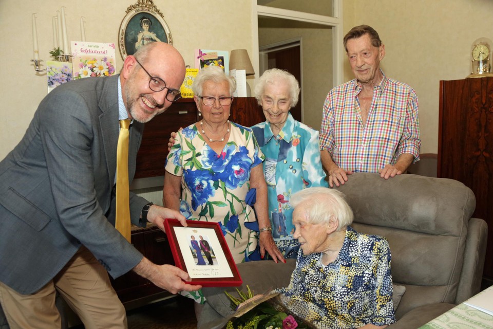Districtsburgemeester Koen Palinckx overhandigt Jeanne Van Dorst een foto van het koningspaar. Achter nicht Maria, buurvrouw Georgette en zoon Alfons. 
