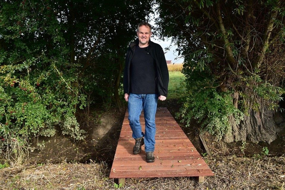 Schepen Patrick Princen wandelt over het nieuw aangelegde bruggetje op de buurtweg Regular.