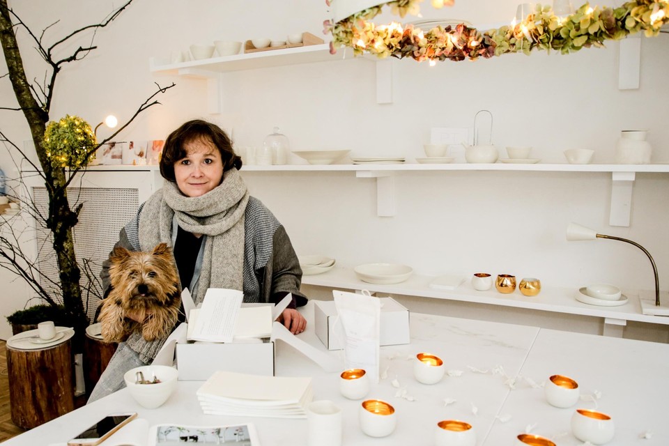 Babhur, het hondje van Anja Meeusen, en de porseleindraaister achter haar theelichtjes en tasjes. Je kan haar boek in combinatie met zo’n handgedraaid porseleinen stuk en speciale PTZE-tea kopen in een doosje. 