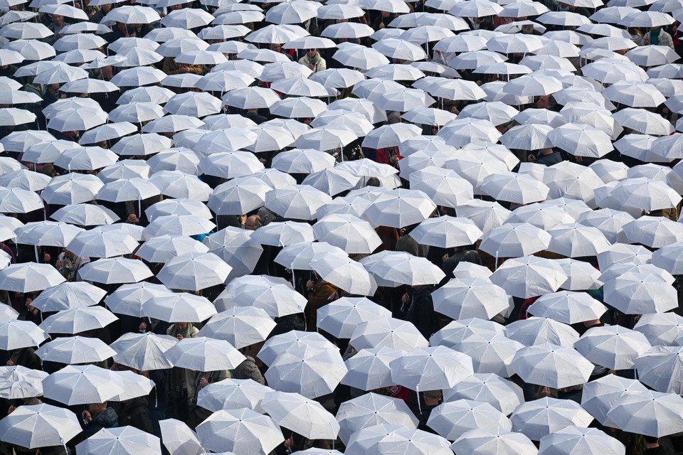 Een zee van witte paraplu’s in Mortsel.