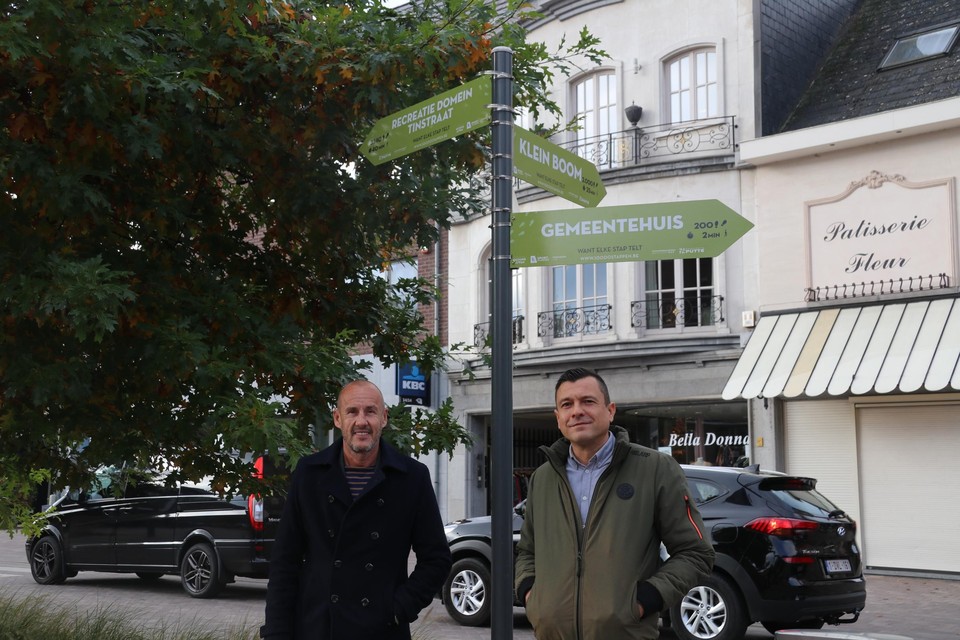 Burgemeester Peter Gysbrechts en schepen Jeroen De Cuyper bij de nieuwe signalisatiebordjes op het kerkplein in Putte-centrum.