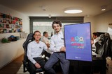 thumbnail: Alexander en Kristof tonen het logo van Onze Vereniging.