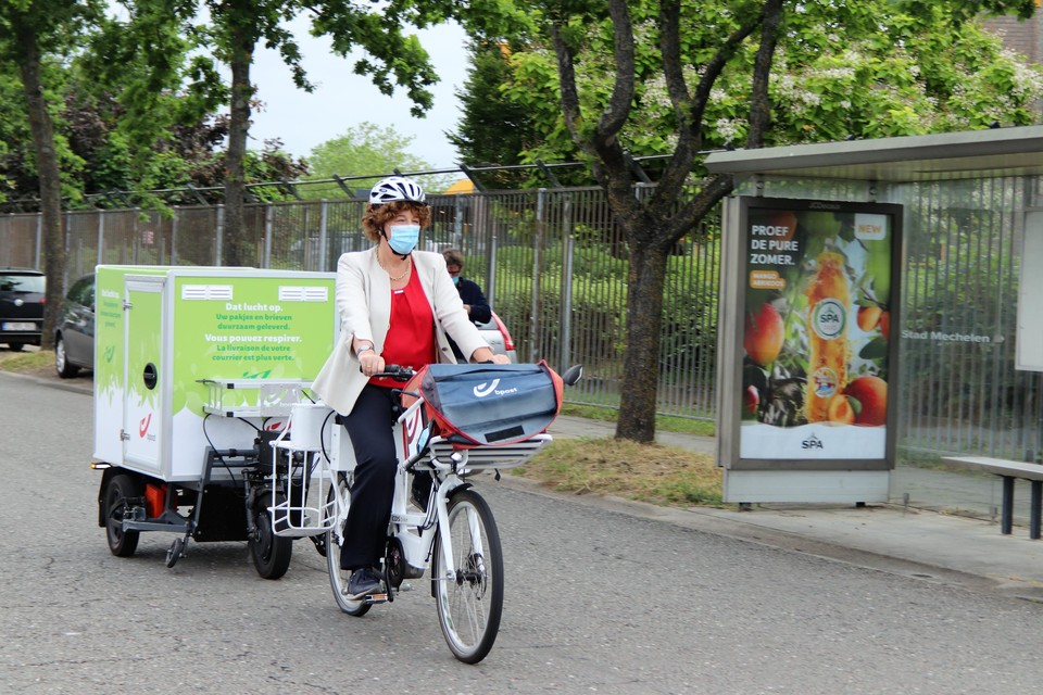 Minister Petra De Sutter test zelf een elektrische fiets met trailer uit. 