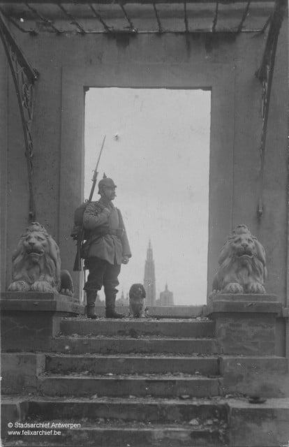 German soldier with his dog.  In the background of the cathedral. 