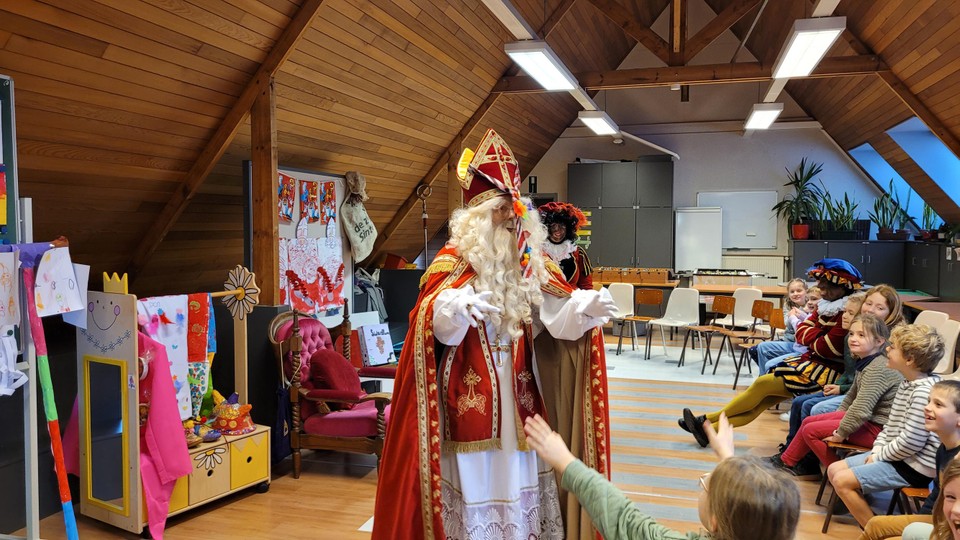 Oei, Piet hangt de das over de mijter van Sinterklaas... die niets meer voor ogen kan zien. 