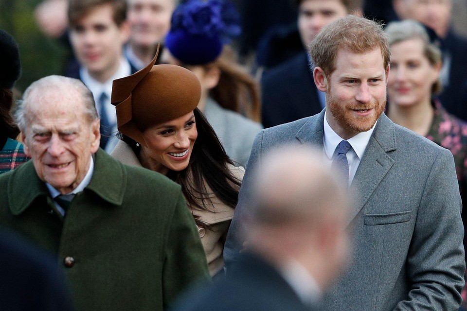 Prins Harry (rechts) zal zaterdag aanwezig zijn op de begrafenis van prins Philip (links), zijn echtgenote Meghan Markle (centraal) blijft op doktersadvies in Californië. 