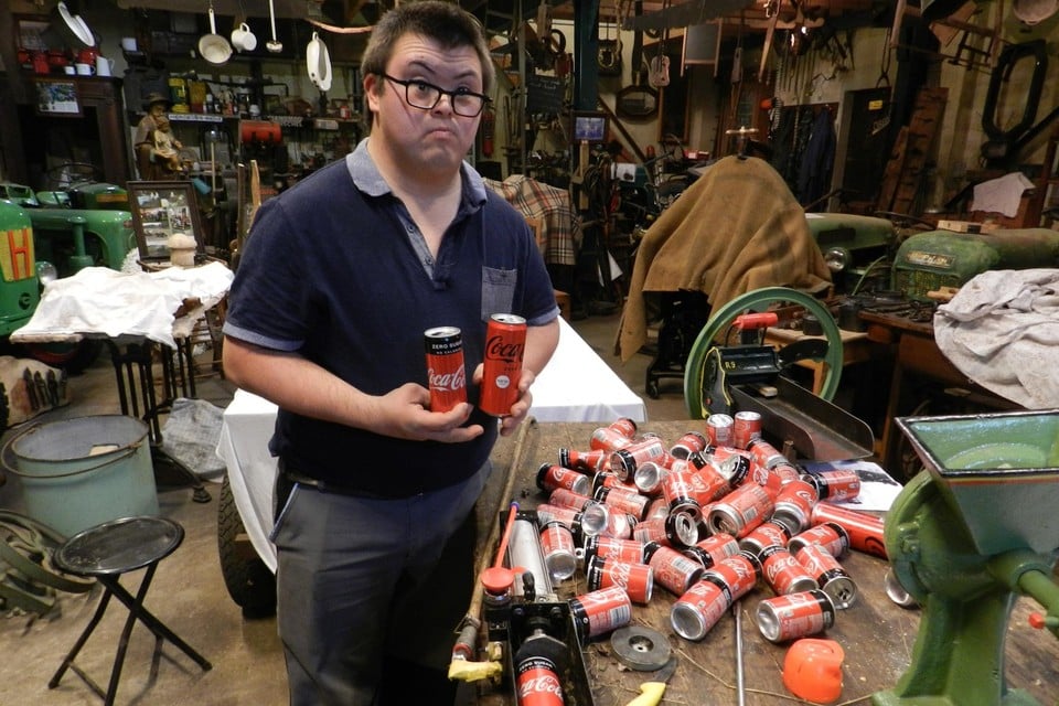 Thijs gebruikt een machine om de blikjes te pletten.