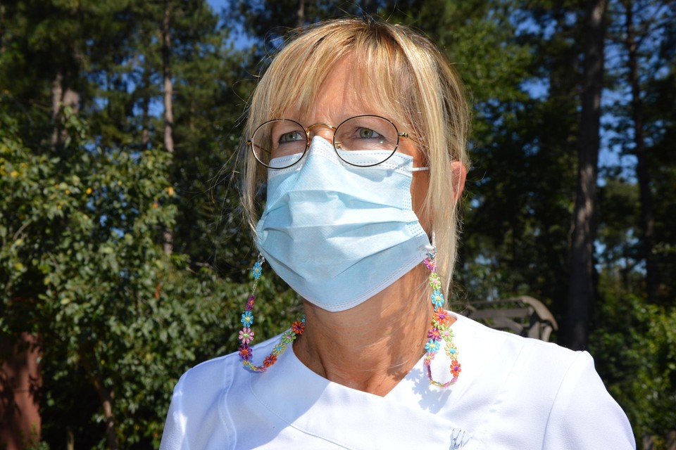 Martine Fornoville met haar mondmasker met koordjes om het aan haar hals te laten hangen. 