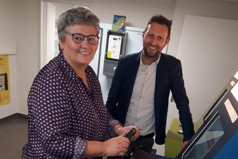 Schepen Elisabeth Joris (DBM) en schepen Wouter Patho (N-VA) testen in het Inleefhuis een spelcomputer van Fluvius. Leerlingen leren spelenderwijs meer over energiefacturen en krijgen tips om er bewuster mee om te gaan.