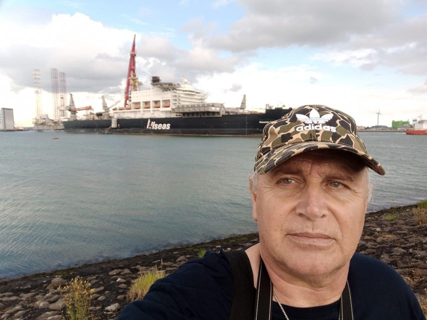 Een droge Luc van Haute maakt een selfietje met het grootste schip ter wereld. 