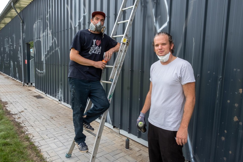 Reinout De Boeck en Tim Van den Brande voor de staantribune van Berchem Sport. Dit weekend begonnen ze aan de zeventig meter lange graffiti. 
