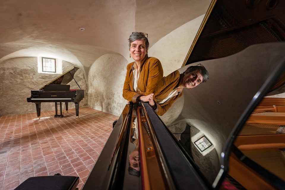 Benedikte Van Garsse bij enkele vleugelpiano’s in de gewelfde kelder van het Hof van Cortenbach. 