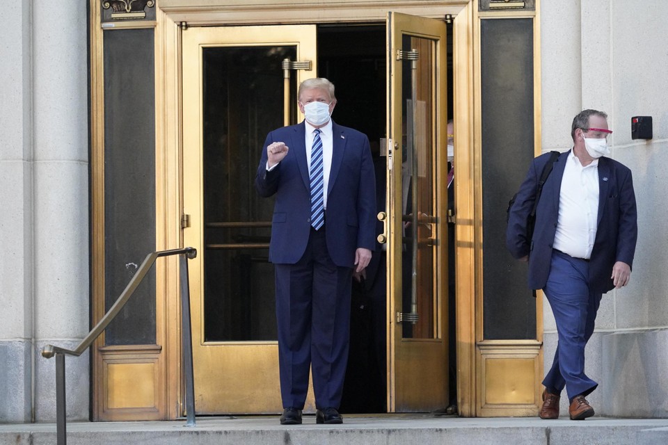 Trump poseerde eerst met masker buiten de ziekenhuisdeuren. 