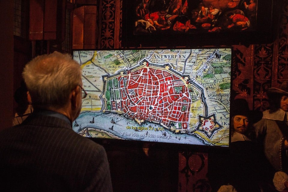 Fernand Huts kijkt naar een beeld over Antwerpen in de 16e eeuw. 