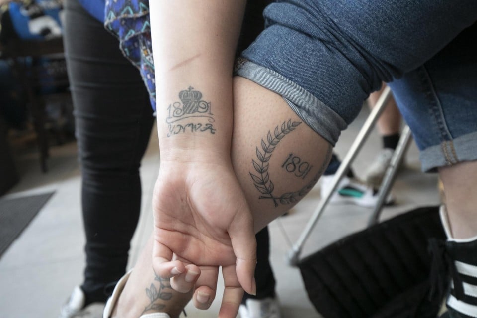 Kelly en Lotte tonen met trots hun Club Brugge-tattoo. Het getal 1891 representeert het geboortejaar van hun geliefde voetbalclub. 