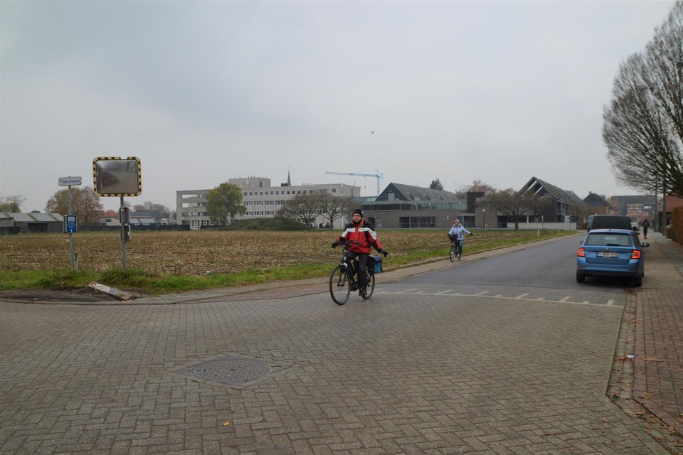 Het kruispunt van de Pater Domstraat en de Kapelstraat. De nieuwe verkaveling zou op de akker achter de fietsers komen. 