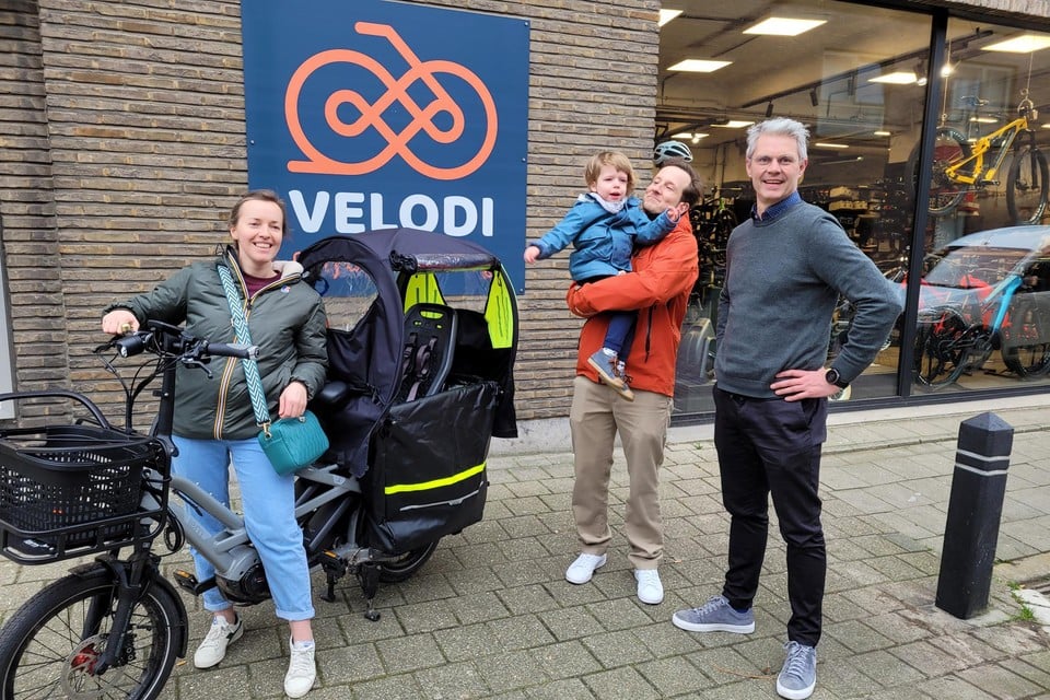 Sofie en Ive met hun nieuwe fiets voor Emile aan fietswinkel Velodi van David ibens (rechts).