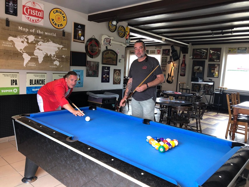 Uitbater Nico van Gestel test samen met buurman TomNaso Ooghe (links) de poolbiljart al uit in café De Willaert in Tielen.