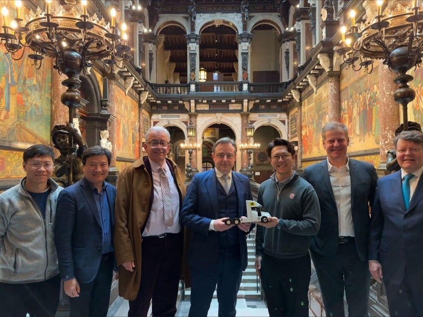 Wen Han, de oprichter van Windrose, staat op de foto in het Antwerpse stadhuis met onder meer burgemeester De Wever en de Antwerpse Voka-chef Luc Luwel.