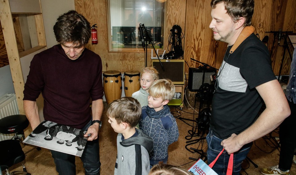 Rik hands an old Clouseau LP to Koen Wauters.  “Will you sign it for my mom and dad please?”  André de Laat looks on with amusement. 