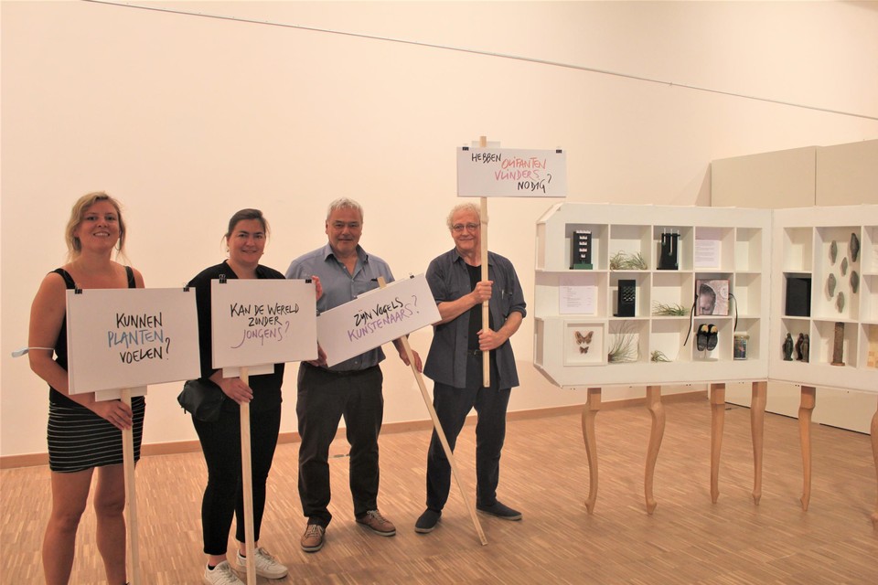De filosofische vragen werden op bordjes geschreven als een knipoog naar de klimaatbetogingen, zegt Danny Van Rumste (rechts), die naast een ‘Wonderkamer’ met kunstwerkjes staat.
