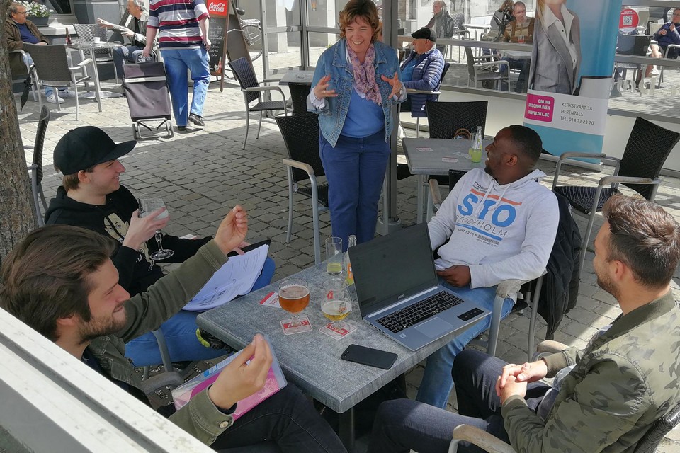 Studenten Seppe Stroobants, Jef Brabants, Wietse Bosmans en Solomon Mawumawu krijgen op het terras van café Druyts les van informaticaleerkracht Marijke Vandoninck.