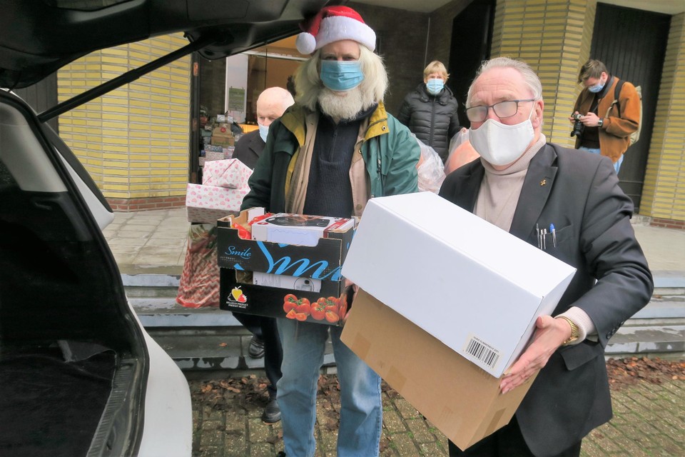 Wiebe Eekman (PVDA) (l) en diaken Luc Dekelver laden samen de kerstgeschenken in. 